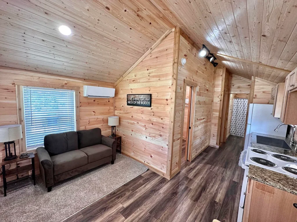 Fully decorated wooden park model home with sofa, table lamp, etc.,